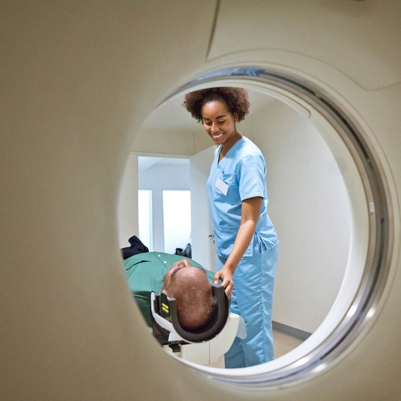 Nurse helping a patient receive diagnostic imaging